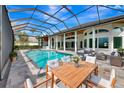 The screened-in outdoor pool area features a spa and stylish patio furniture for relaxing and entertaining at 600 Eagle Watch Ln, Osprey, FL 34229