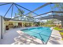 Sparkling screened pool with a lounge area, complemented by lush landscaping at 6540 Prairie Junction Trl, Sarasota, FL 34241