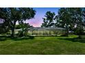 Enclosed screened patio with ample space, lush plantings, and a view of the landscaped backyard at 6540 Prairie Junction Trl, Sarasota, FL 34241