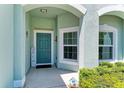 Welcoming front porch with a teal front door, window, and quaint decor at 736 Rosemary Cir, Bradenton, FL 34212