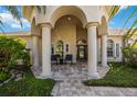 Charming front porch with stately columns and comfortable seating at 7581 Camden Harbour Dr, Bradenton, FL 34212