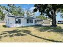 The rear exterior of a white home with a screened porch and green lawn at 1028 36Th E Ave, Ellenton, FL 34222