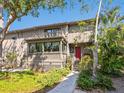 Inviting home exterior with a red front door, porch and manicured front yard at 1493 Gulf Of Mexico Dr #312, Longboat Key, FL at 1493 Landings Lake Dr # 32, Sarasota, FL 34231