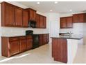 Well-equipped kitchen with sleek black appliances, granite countertops, ample wood cabinetry, and a center island at 15543 Trinity Fall Way, Bradenton, FL 34212