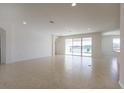 Bright and airy living room featuring neutral tile flooring and expansive sliding glass doors offering backyard views at 15543 Trinity Fall Way, Bradenton, FL 34212
