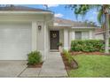 Close-up of the front door and walkway, enhanced by garden and a decorative wreath at 18106 Canal Pointe St, Tampa, FL 33647