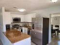 Updated kitchen with stainless steel appliances, granite countertops, and white cabinets at 2035 Vinson Ave, Sarasota, FL 34232