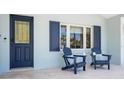 Inviting front porch with comfortable seating, dark door, and large windows with dark shutters at 204 75Th St, Holmes Beach, FL 34217