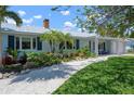 Landscaped front yard featuring a stone pathway, vibrant plants, and well-manicured lawn at 204 75Th St, Holmes Beach, FL 34217