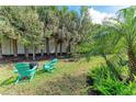 Serene backyard featuring Adirondack chairs, privacy trees, lush landscaping, and a tranquil setting at 224 Soliera St, Nokomis, FL 34275
