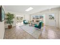 Bright living room with tile flooring, large windows, skylight, and comfortable seating arrangement at 2551 Waneta Dr, Sarasota, FL 34231