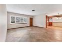 Open living room with large windows, tile floors, and view of the adjacent dining area at 3072 Meyer Dr, Sarasota, FL 34239