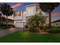 Beautiful two-story home boasting stone accents, a paved driveway, and lush landscaping with mature palm trees at 3210 Desert Plain Cv, Lakewood Ranch, FL 34211
