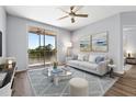 Bright and airy living room with hardwood floors and a sliding glass door to the balcony with water views at 4138 Central Sarasota Pkwy # 1524, Sarasota, FL 34238