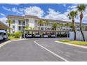 Low-rise apartment building with covered parking, professional landscaping and decorative palm trees at 4310 Falmouth Dr # 305, Longboat Key, FL 34228