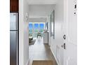 Hallway leading to living space with water view, and stainless steel refrigerator on the left at 4310 Falmouth Dr # 305, Longboat Key, FL 34228
