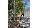 Exterior view of the garage with a side yard and tree line at 4639 Sloan Ave, Sarasota, FL 34233