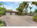 Spacious paved driveway leading to a two-car garage, surrounded by mature trees and lush greenery at 501 Sloop Ln, Longboat Key, FL 34228