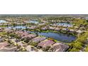 Beautiful aerial view of the community with lake view, manicured lawns, and tile roofs at 5509 Avellino Pl, Sarasota, FL 34238