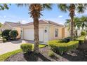 Inviting home exterior with lush landscaping, manicured shrubs, palm trees, and a red tile roof at 5509 Avellino Pl, Sarasota, FL 34238