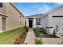 Inviting walkway leads to the front door, with colorful flowers and landscaped greenery at 5547 Logan Cave Ave, Wimauma, FL 33598