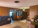 Comfortable living room with traditional wood paneling and carpet leading to a dining area at 6324 Case Ave, Bradenton, FL 34207
