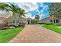 Inviting single-story home with a brick driveway, well-manicured lawn, and a two-car garage at 643 Misty Pond Ct, Bradenton, FL 34212