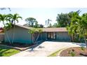 Charming single-story home featuring a well-manicured lawn, mature palm trees, and a private two-car garage at 7019 10Th S St, St Petersburg, FL 33705