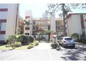 View of the condo's exterior, featuring multiple balconies, palm trees, and landscaped grounds at 7500 40Th W Ave # 209, Bradenton, FL 34209