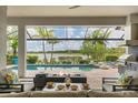 Inviting outdoor patio with fire pit overlooking sparkling pool and peaceful lake views at 8258 Grande Shores Dr, Sarasota, FL 34240