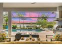 Inviting outdoor patio with fire pit overlooking sparkling pool and peaceful lake views at 8258 Grande Shores Dr, Sarasota, FL 34240