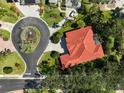 Aerial view of a single story home with a red tile roof, circular driveway, mature trees and lush landscaping at 901 Reflection Way, Osprey, FL 34229