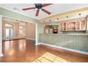 Open-concept living space featuring hardwood floors, columns, and a bar area for seamless entertaining at 919 80Th Nw St, Bradenton, FL 34209
