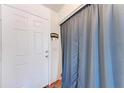 Bright entryway featuring a white door, complemented by the adjacent curtain and wood floors at 1026 Longfellow Ct # 111, Sarasota, FL 34243