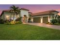 Beautiful single-Gathering home with a tile roof, three-car garage, and lush landscaping at sunset at 12020 Legacy Estates Blvd, Sarasota, FL 34238