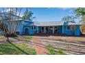 Charming blue home featuring a spacious front porch with brick steps, creating a welcoming entrance at 1479 Bay Point Dr, Sarasota, FL 34236