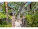 Welcoming brick-paved courtyard entrance between townhomes with lush greenery and mature trees at 1490 Mahogany Ln # 706, Palm Harbor, FL 34683
