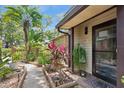 Inviting front entrance with lush tropical landscaping and charming walkway to front door at 1490 Mahogany Ln # 706, Palm Harbor, FL 34683