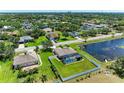 Aerial view of home with screened-in pool, fenced yard, and pond on a lush, green lot at 1603 21St W Ave, Palmetto, FL 34221