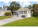 Attractive yellow house with a lovely screen porch, neat lawn, and paved driveway in a quiet setting at 182 Crown Point Dr, Nokomis, FL 34275
