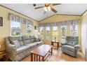 Bright living room featuring a comfortable sofa, armchair, wood laminate floors, and plenty of natural light at 182 Crown Point Dr, Nokomis, FL 34275