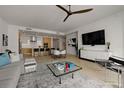 Open-concept living area with modern furnishings and a stylish kitchen in the background at 301 Quay Commons # 1204, Sarasota, FL 34236