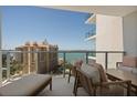 Relaxing balcony seating with amazing views of the water and surrounding city buildings on a clear, sunny day at 301 Quay Commons # 1610, Sarasota, FL 34236