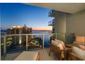 Relaxing balcony seating with amazing views of the water and surrounding city buildings during a colorful dusk at 301 Quay Commons # 1610, Sarasota, FL 34236
