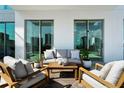 A modern balcony featuring comfortable outdoor seating, creating an inviting space for relaxation with city views at 301 Quay Commons # 507, Sarasota, FL 34236