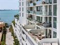 Multi-story building showing multiple private balconies overlooking the ocean with clear glass railings at 301 Quay Commons # 507, Sarasota, FL 34236