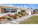 Charming home with colorful flower beds, stone walkway, and well-maintained lawn at 309 Glen Oak Rd, Venice, FL 34293