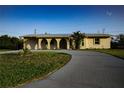 Charming home featuring a large, paved driveway and a well-manicured lawn at 389 Millport Nw St, Port Charlotte, FL 33948