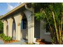 Close-up of arched front porch featuring updated beige paint, landscaping, and modern front door at 389 Millport Nw St, Port Charlotte, FL 33948