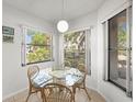 Bright dining area featuring a glass table, four chairs, and large windows with natural light at 4325 46Th W Ave # 104, Bradenton, FL 34210